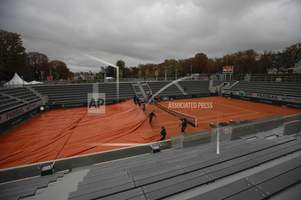 Alessandra Tarantino Stadium workers cover courts as rain suspended most third round matches of the French Open tennis tournament at the Roland Garros stadium in Paris, France, Friday, Oct. 2, 2020. (AP Photo/Alessandra Tarantino)