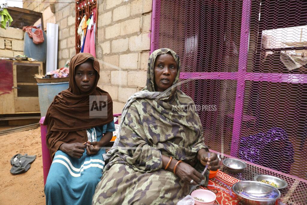 Marwan Ali Saadia Ahmed, mother of the Sudanese migrant Mutawakel Ali, sits with her daughter at her home, in Khartoum, Sudan, Friday April 30, 2021. Ali narrowly missed drowning in Libya because he was late for the boat’s departure. The rubber boat when on to sink at sea on approximately April 21, and its more than 100 passengers drowned. (AP Photo/Marwan Ali)