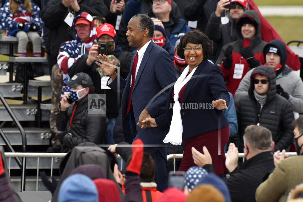 Jose Juarez Housing and Urban Development Secretary Ben Carson, left, and his wife, Candy Carson, walk on stage at a campaign rally for President Donald Trump at Oakland County International Airport, Friday, Oct. 30, 2020, in Waterford Township, Mich. (AP Photo/Jose Juarez)