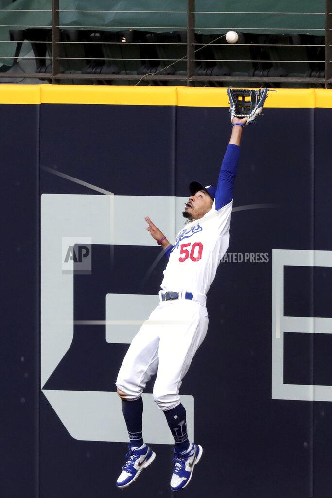Curtis Compton Los Angeles Dodgers right fielder Mookie Betts makes a catch against the outfield wall robbing a home run from Atlanta Braves designated hitter Marcell Ozuna of a hit during the fifth inning in Game 6 of baseball’s National League Championship Series, Saturday, Oct. 17, 2020, in Arlington, Texas. (Curtis Compton/Atlanta Journal-Constitution via AP)