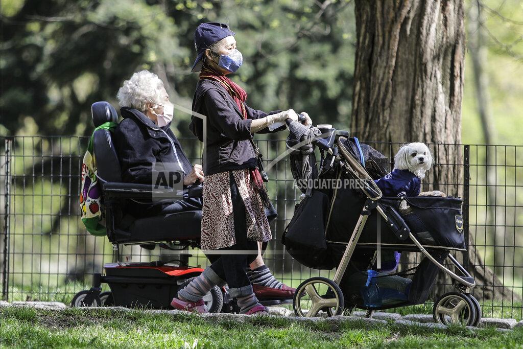 People wearing protective masks enjoy Central Park Saturday, May 2, 2020, in New York. New York City police dispatched 1,000 officers this weekend to enforce social distancing due to coronavirus concerns, as warmer weather tempted New Yorkers to come out of quarantine. Officers set out on foot, bicycles and cars to break up crowds and remind everyone of public health restrictions requiring they keep 6 feet away from others.(AP Photo/Frank Franklin II)