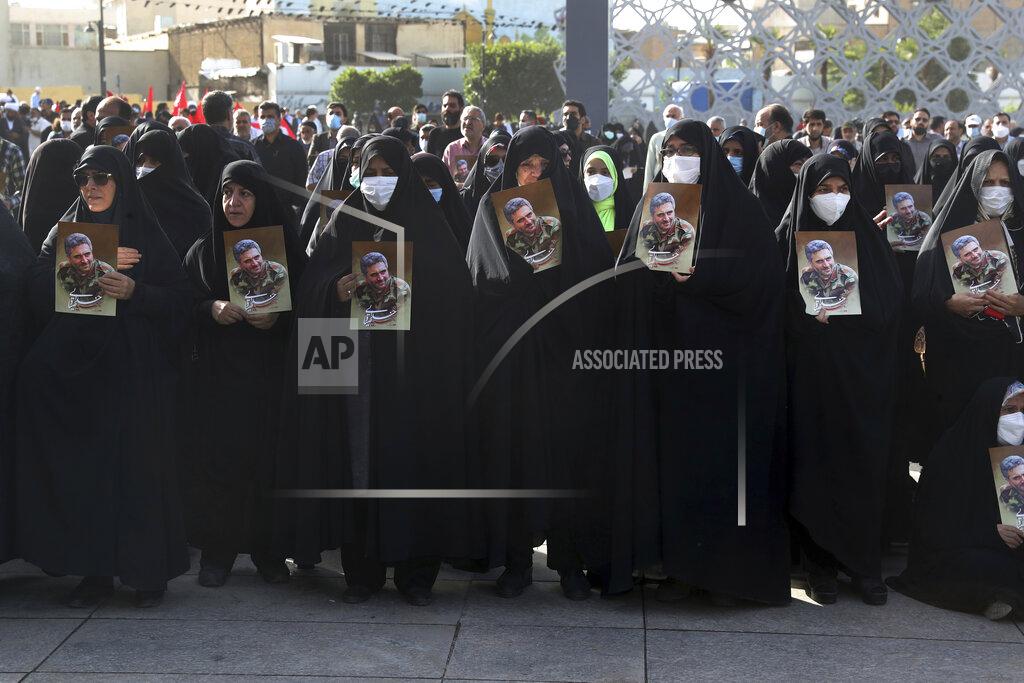 Vahid Salemi Mourners hold posters of Iran's Revolutionary Guard Col. Hassan Sayyad Khodaei during his funeral ceremony in Tehran, Iran, Tuesday, May 24, 2022. Iran's hard-line President Ebrahim Raisi vowed revenge on Monday over the killing of Sayyad Khodaei who was shot at his car by two assailants outside his home in Tehran, a still-mysterious attack on the country's powerful paramilitary force. (AP Photo/Vahid Salemi)