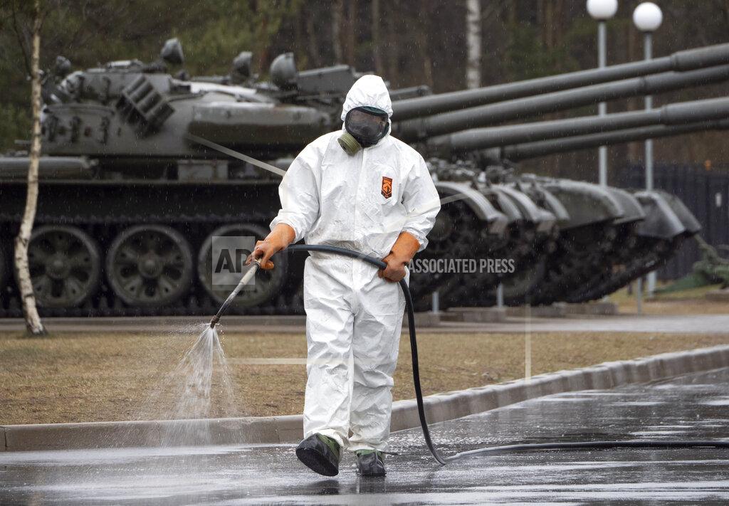 Dmitri Lovetsky A specialist from a local veterinary service wears a protective suit as sprays disinfectant near Russian tanks displayed at area near Proryv (The Breakthrough) museum dedicated to the breakthrough of the Siege of Leningrad during World WarII near Kirovsk, about 30 kilometres (19 miles) east of St.Petersburg, Russia, Thursday, April 2, 2020. The new coronavirus causes mild or moderate symptoms for most people, but for some, especially older adults and people with existing health problems, it can cause more severe illness or death. (AP Photo/Dmitri Lovetsky)