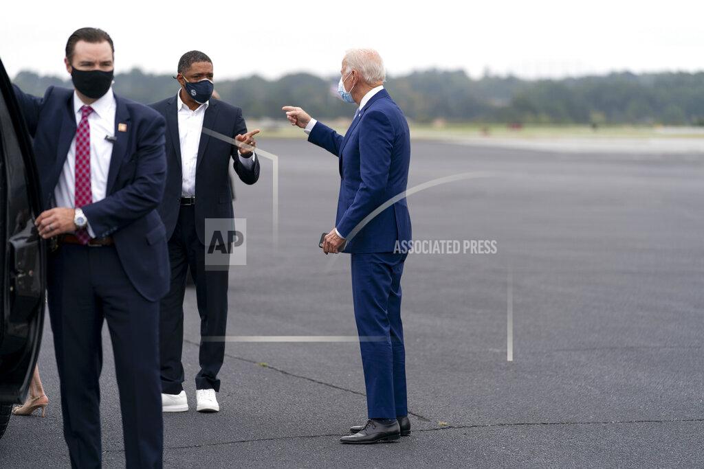 Andrew Harnik Democratic presidential candidate former Vice President Joe Biden speaks with Rep. Cedric Richmond, D-La., second from left, as he arrives at Columbus Airport in Columbus, Ga., Tuesday, Oct. 27, 2020, to travel to Warm Springs, Ga. for a rally. (AP Photo/Andrew Harnik)