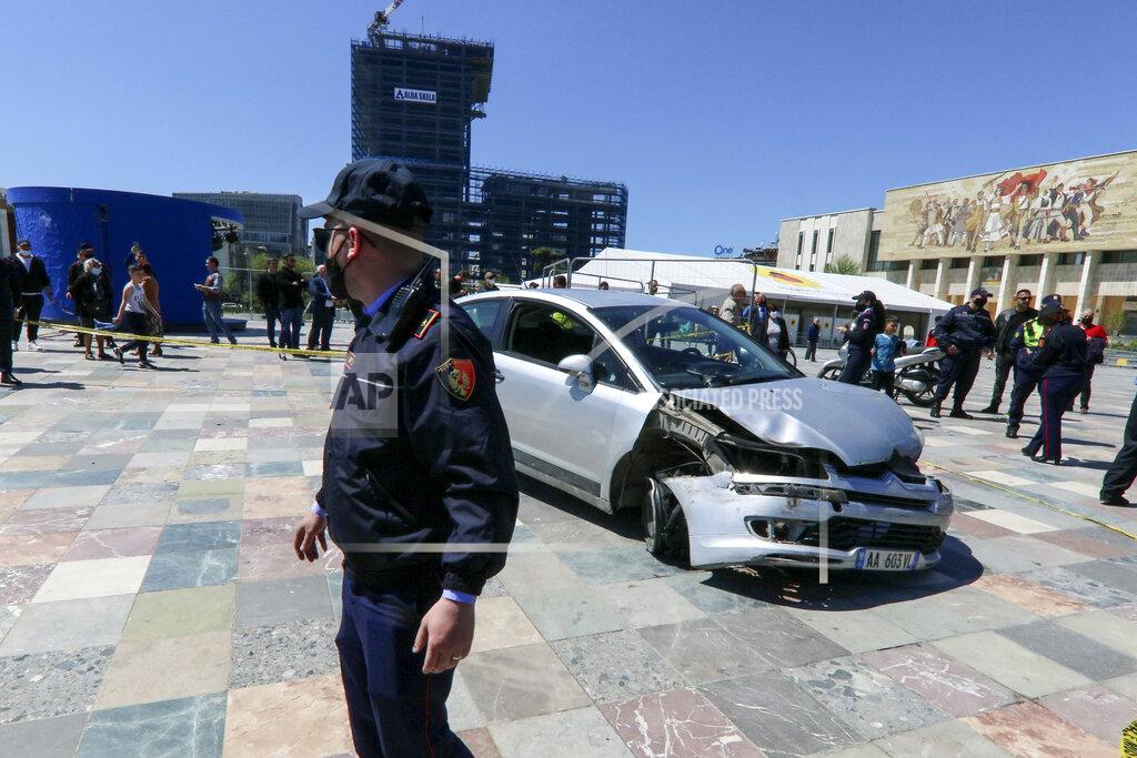 Hektor Pustina A police officer stands near to a damaged car on central Skanderbeg square, after an incident, in Tirana, Sunday, April 25, 2021. A man drove his car into the Albanian capital Tirana’s main square where vehicles are not allowed, the local media and police reported on Sunday. The driver broke the barriers to enter the Skanderbeg Square. A young man managed to stop the driver entering from the window. Then people dragged him out of the car. No one was injured. The car stopped near two big tents where people get vaccines and a smaller tent raised from the Syri Televizion private channel to cover the voting. (AP Photo/Hektor Pustina)