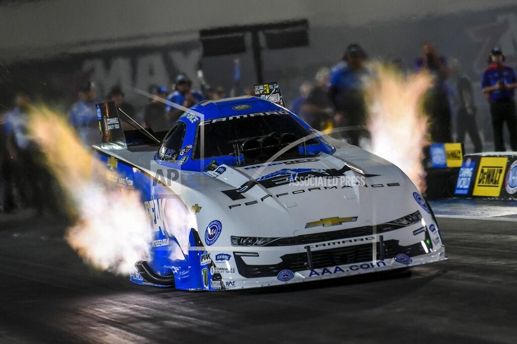 In this photo provided by the NHRA, Funny Car points leader John Force races to the provisional No. 1 position in his first-round qualifying run in his PEAK Chevrolet Camaro SS at the DeWalt NHRA Carolina Nationals at zMAX Dragway in Concord, N.C., Friday, Sept. 17, 2021 (Richard H. Shute/NHRA via AP)
