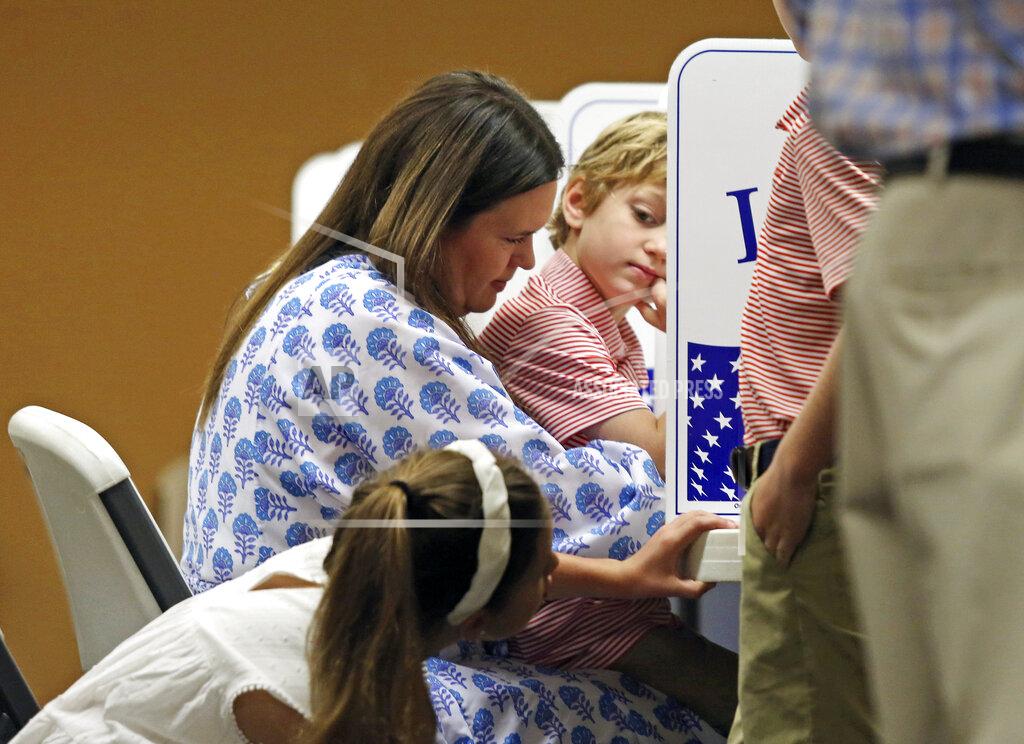 Colin Murphey Gubernatorial candidate Sarah Huckabee Sanders, center, casts her vote with children Scarlett, left, and George at a polling station located in the Pleasant Valley Church of Christ in Little Rock, Ark., Tuesday, May 24, 2022. (Colin Murphey/The Arkansas Democrat-Gazette via AP)