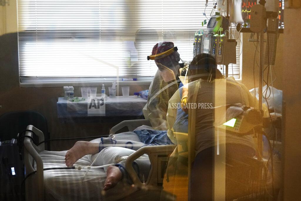 Gerald Herbert FILE - In this Aug. 18, 2021, file photo, medical staff tend to a patient with coronavirus, on a COVID-19 ward inside the Willis-Knighton Medical Center in Shreveport, La. COVID-19 deaths and cases in the U.S. have climbed back to where they were over the winter, wiping out months of progress and potentially bolstering President Joe Biden’s case for sweeping new vaccination requirements. (AP Photo/Gerald Herbert, File)