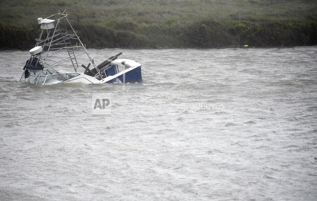 Annie Rice A boat sinks in the Packery Channel during Hurricane Hanna, Saturday, July 25, 2020, in North Padre Island, Texas. The Category 1 storm continued to strengthen before reaching Padre Island at 5 p.m. Saturday. (Annie Rice/Corpus Christi Caller-Times via AP)