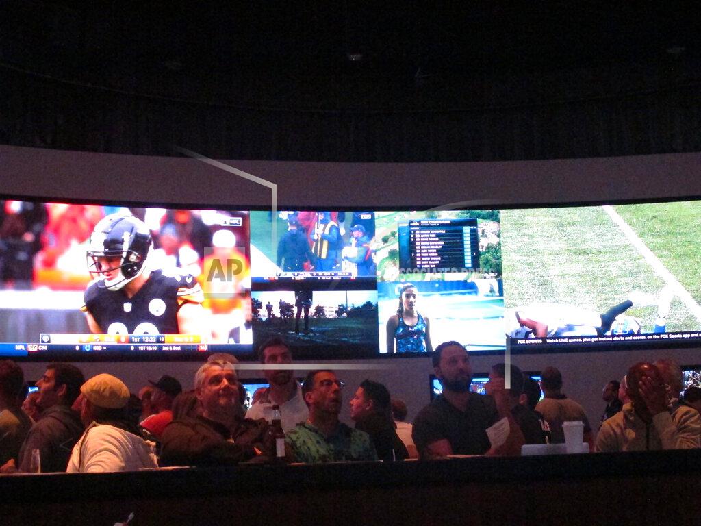 Wayne Parry Football fans watch the action on wall-mounted video screens in the sports betting lounge at the Ocean Resort Casino in Atlantic City, N.J. on Sunday Sept. 9, 2018. The coronavirus virus outbreak has added new wrinkles for bettors this year,but even so, the nation's sports books expect a record year of bets on football in 2020 from an antsy public that has been cooped up for months amid the pandemic. (AP Photo/Wayne Parry)