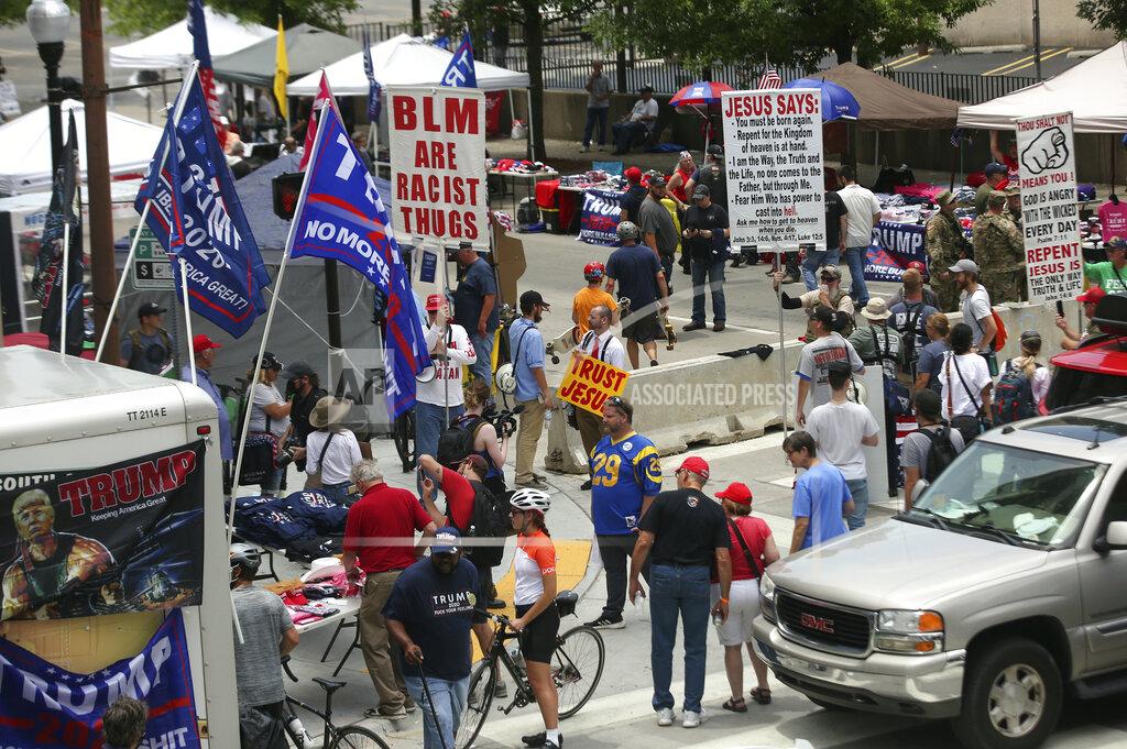 John Clanton People gather as they make their way toward BOK Center in downtown Tulsa, Okla., ahead of President Donald Trump's planned rally Saturday, June 20, 2020. (John Clanton/Tulsa World via AP)