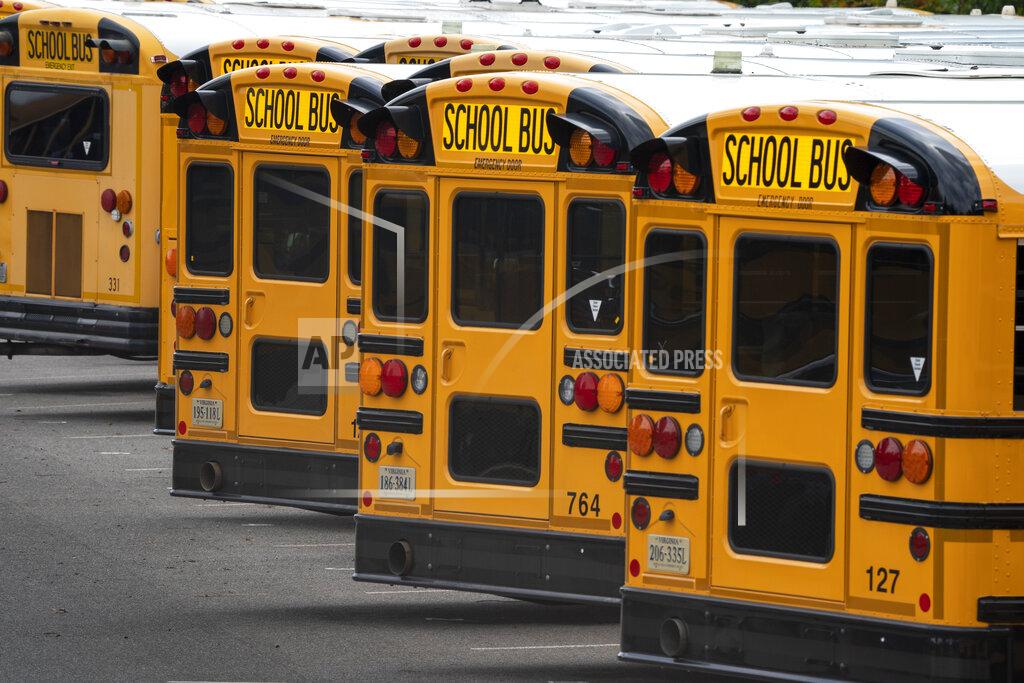 Fairfax County Public School buses are lined up at a maintenance facility in Lorton, Va., Friday, July 24, 2020. The nation's 10th largest school district plans an all-virtual start to the fall semester amid the Covid-19 pandemic. (AP Photo/J. Scott Applewhite)