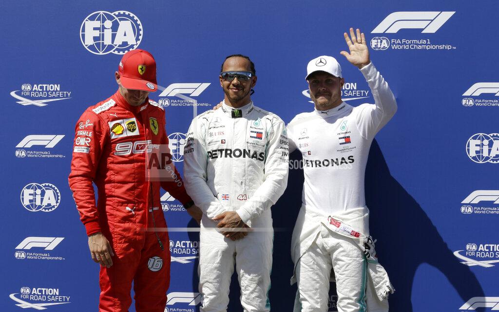 Claude Paris Mercedes driver Lewis Hamilton of Britain, center, who earned pole position, Ferrari driver Charles Leclerc of Monaco, left, who came in third and Mercedes driver Valtteri Bottas of Finland, who earned the second best time, posing for photos after the qualifying session at the Paul Ricard racetrack in Le Castellet, southern France, Saturday, June 22, 2019. The French Formula One Grand Prix will be held on Sunday. (AP Photo/Claude Paris)