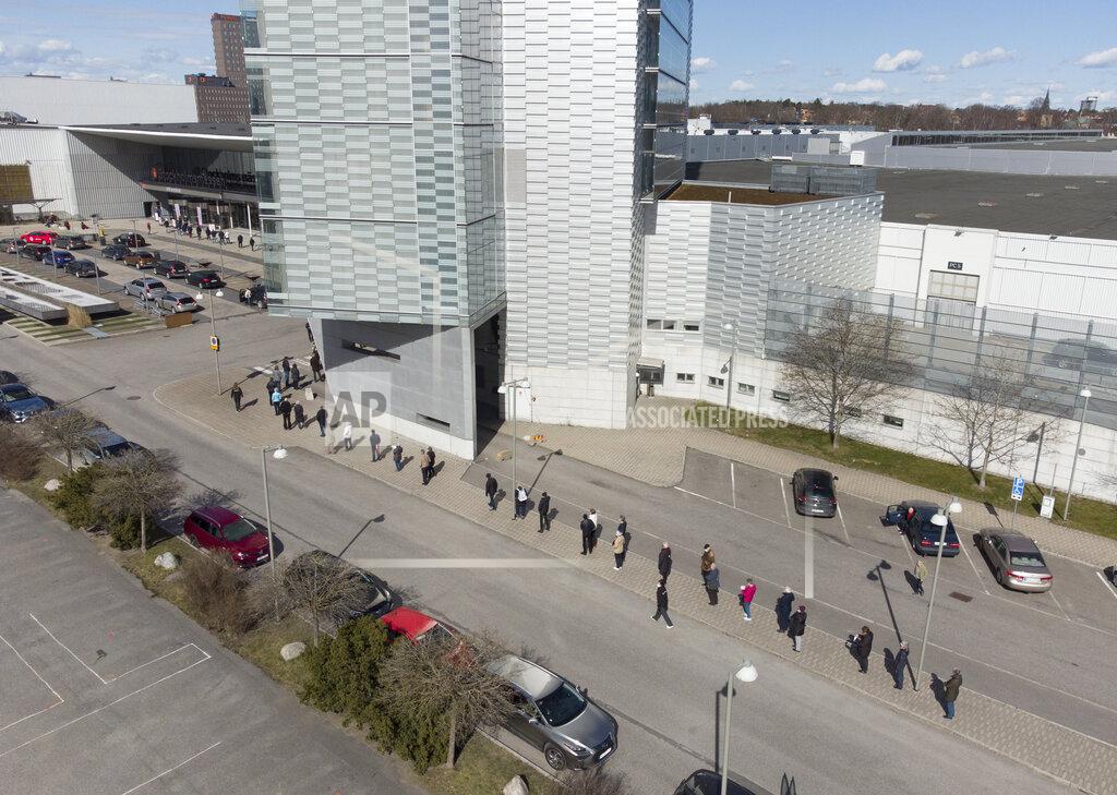 Fredrik Sandberg People queue to receive a dose of a COVID-19 vaccine, outside the Stockholmsmassan exhibition center turned mass vaccination center, in Stockholm, Sweden, Thursday April 8, 2021. (Fredrik Sandberg/TT News Agency via AP)