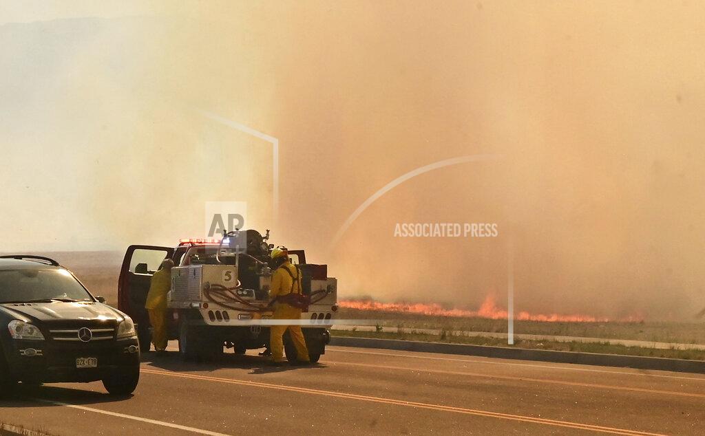 Jerilee Bennett FILE - A firefighting crew arrives at the scene of a field on fire adjacent to the Amazon Distribution Center in Colorado Springs, Colo., on May 12, 2022. More than 5,000 firefighters are battling multiple wildland blazes in dry, windy weather across the Southwest. Evacuation orders remained in place Thursday, May 19, 2022, for residents near fires in Texas, Colorado and New Mexico. (Jerilee Bennett/The Gazette via AP, File)