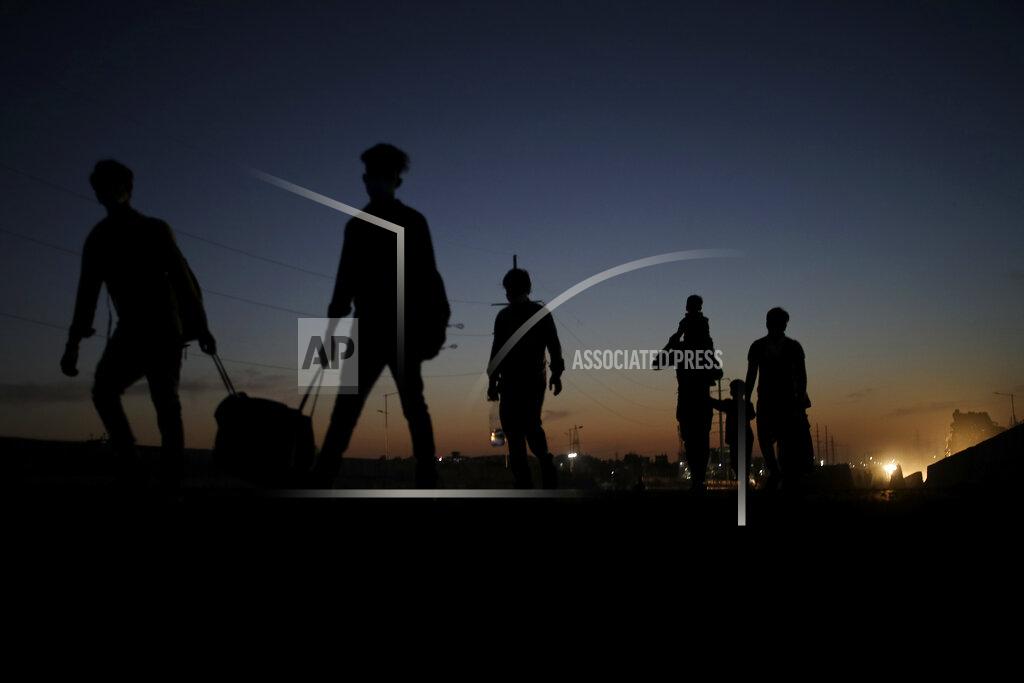A migrant laborer's family ia silhouetted as they proceed towards their village on foot, following a lockdown amid concern over spread of coronavirus in New Delhi, India, Saturday, March 28, 2020. Some of India's legions of poor and others suddenly thrown out of work by a nationwide stay-at-home order began receiving aid on Thursday, as both public and private groups worked to blunt the impact of efforts to curb the coronavirus pandemic. The measures that went into effect Wednesday, the largest of their kind in the world, risk heaping further hardship on the quarter of the population who live below the poverty line and the 1.8 million who are homeless. (AP Photo/Altaf Qadri)