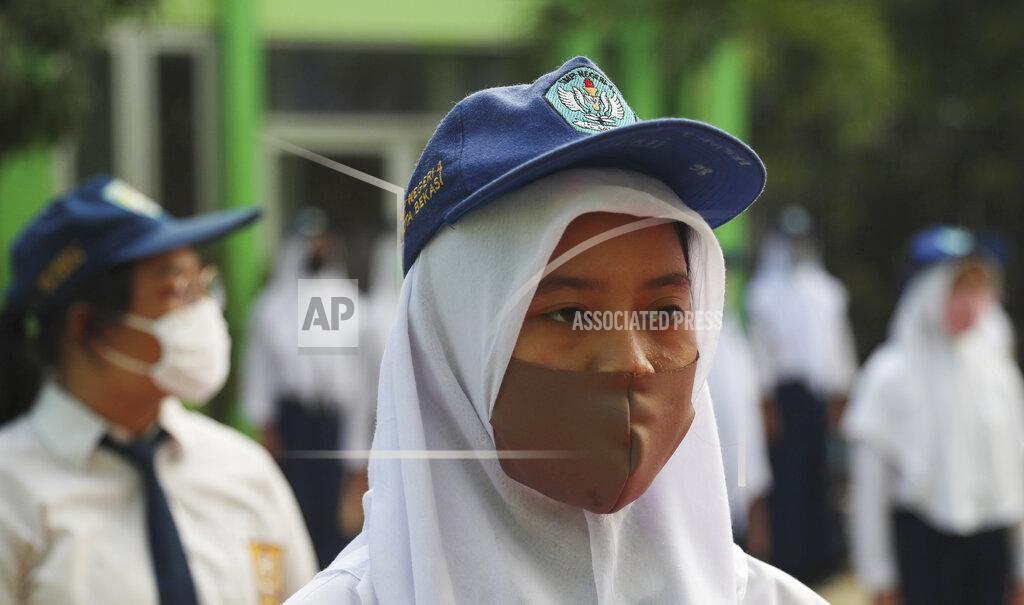 Achmad Ibrahim Students wear face maska as a precaution against the new coronavirus during the first day of reopening of state high schools in Bekasi on the outskirts of Jakarta, Indonesia, July 13, 2020. (AP Photo/Achmad Ibrahim)
