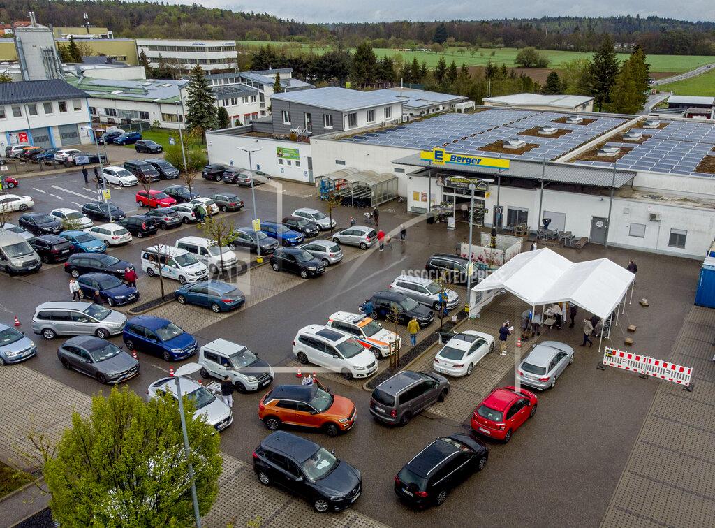Cars with people waiting for AstraZeneca vaccination queue in front of a tent on the parking lot of a supermarket in Pforzheim, southern Germany, Wednesday, May 5, 2021. A doctor who could not get rid of her AstraZeneca vaccine in her doctor's office decided to offer some 250 doses in drive-in location at the supermarket. (AP Photo/Michael Probst)