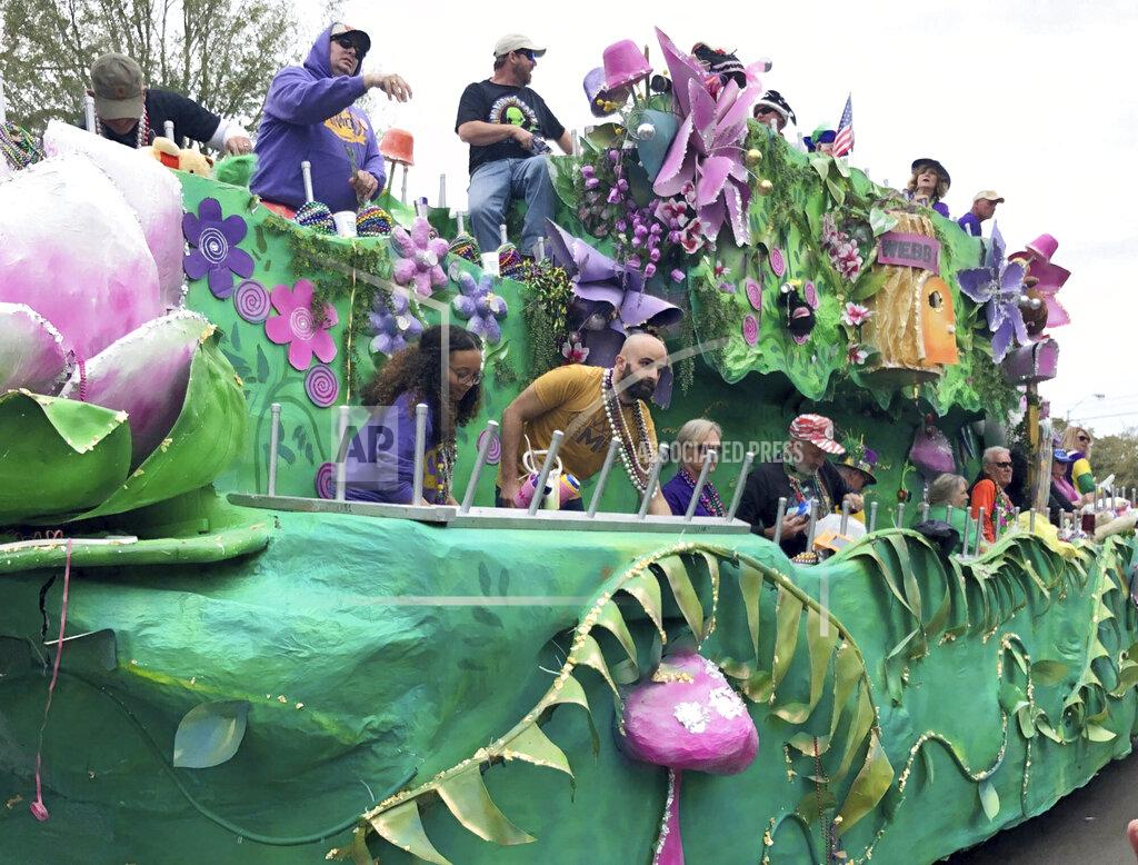 Paul Newberry Float riders toss beads and other items to crowds during a Mardi Gras parade in Mobile, Ala., Sunday, Feb. 23, 2020. With both COVID-19 hospitalizations and vaccinations ebbing, Alabama's port city is putting on a Mardi Gras-style parade on Friday night, May 21, 2021, that will feel at least a little like the Carnival celebrations that were canceled earlier this year because of the pandemic. (AP Photo/Paul Newberry)