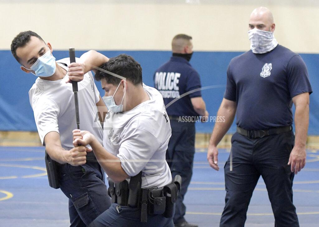 Steve Ruark Baltimore city police trainee Antonio Martinez, second from left, of Philadelphia, defends his baton against trainee Maurice Rodriguez, left, of Pennington, N.J., as police instructor Robert Lance, right, watches during defense tactic training, Wednesday, Aug. 4, 2021, in Baltimore. (AP Photo/Steve Ruark)