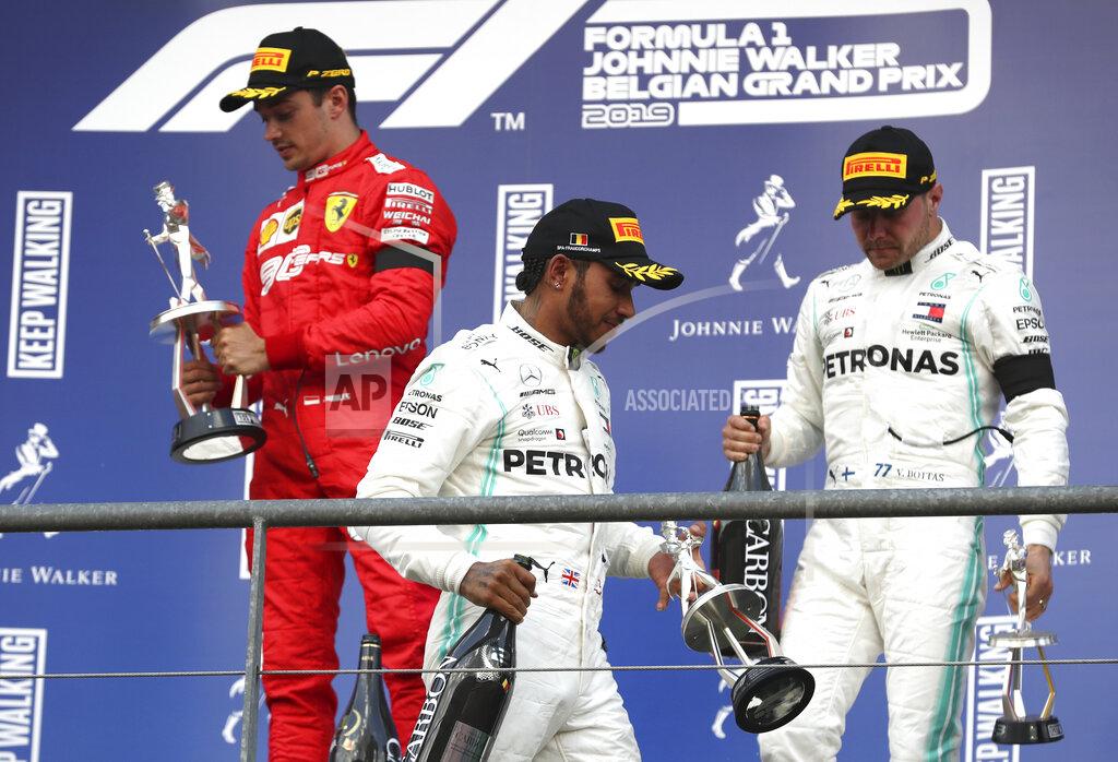 Francisco Seco Ferrari driver Charles Leclerc of Monaco, left, holds his trophy on the podium after finishing first in the Belgian Formula One Grand Prix in Spa-Francorchamps, Belgium, Sunday, Sept. 1, 2019. Mercedes driver Lewis Hamilton of Britain. center, placed second and Mercedes driver Valtteri Bottas of Finland, right, placed third. (AP Photo/Francisco Seco)