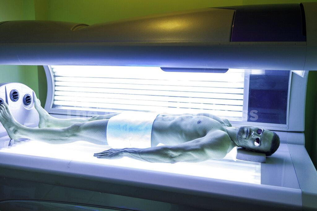 Athlete lying under ultraviolet light bed at health spa Buy Photos AP Images DetailView