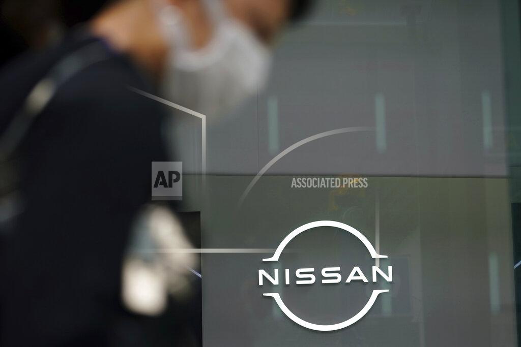 Eugene Hoshiko A man wearing a face mask to to help curb the spread of the coronavirus walks by the logo of Nissan seen at the automaker's showroom in Tokyo Tuesday, May 11, 2021. Nissan reduced its losses for January-March, compared to last year, as restructuring efforts kicked in, despite the sales damage from the coronavirus pandemic, the Japanese automaker said Tuesday. (AP Photo/Eugene Hoshiko)