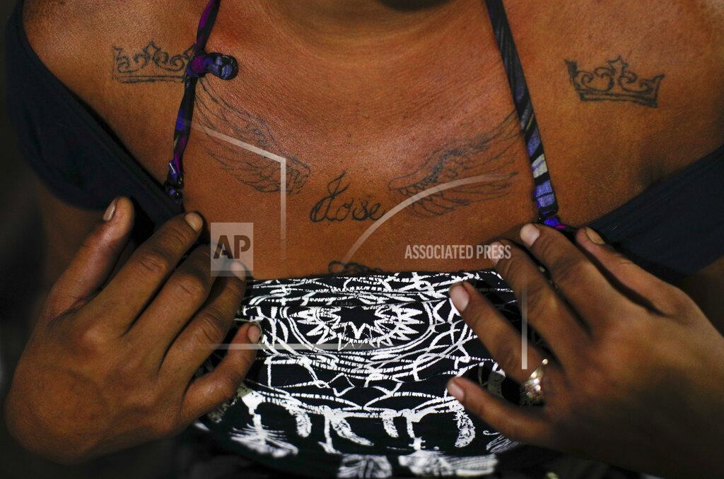 A 27-year-old sex worker who goes by the name Angora shows the tattoo she had done to remember her 14-year-old brother Jose, who was murdered back home in Honduras after becoming an assistant to a group of horse thieves, as she waits for clients outside the Revolution subway station in Mexico City, Tuesday, March 9, 2021. Angora says the competition for clients since the coronavirus pandemic began has exacerbated discrimination against immigrant sex workers from Central America in Mexico City. (AP Photo/Rebecca Blackwell)