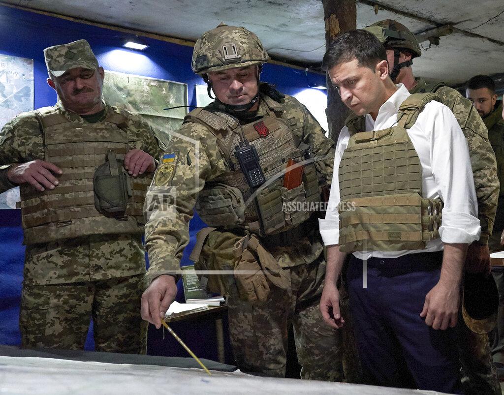 Uncredited FILE - In this file photo taken on Oct. 14, 2019, Ukrainian President Volodymyr Zelenskiy, right, listens to a serviceman as he visits the war-hit Donetsk region, eastern Ukraine. Ukraine badly needs strong bipartisan U.S. support amid a tug-of-war with Russia, which annexed Ukraine's Crimea in 2014 and has backed a separatist insurgency in eastern Ukraine. Ukraine — which has played an unwitting backstage role in American political battles of late — is walking a thin line: trying to avoid being drawn into U.S. election drama, while also not being forgotten by the powers in Washington. (Ukrainian Presidential Press Office via AP, File)