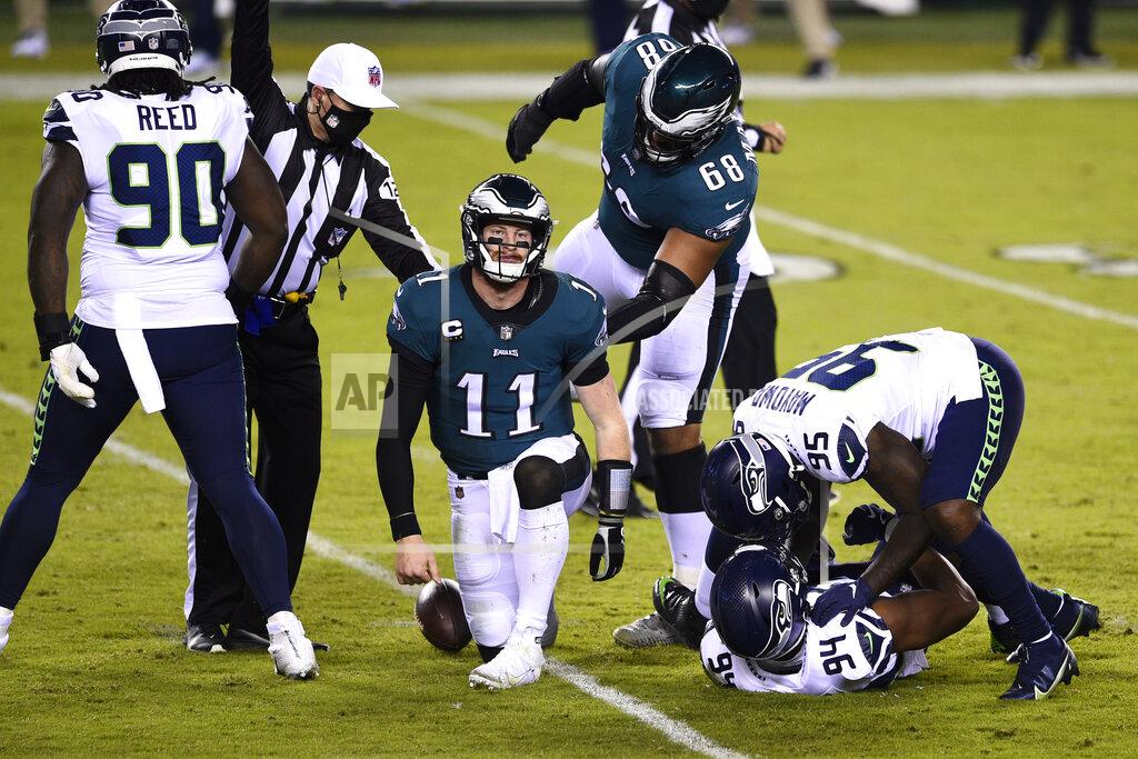 Derik Hamilton Philadelphia Eagles' Carson Wentz (11) reacts after being tackled by Seattle Seahawks' Rasheem Green (94) and Benson Mayowa (95) during the first half of an NFL football game, Monday, Nov. 30, 2020, in Philadelphia. (AP Photo/Derik Hamilton)