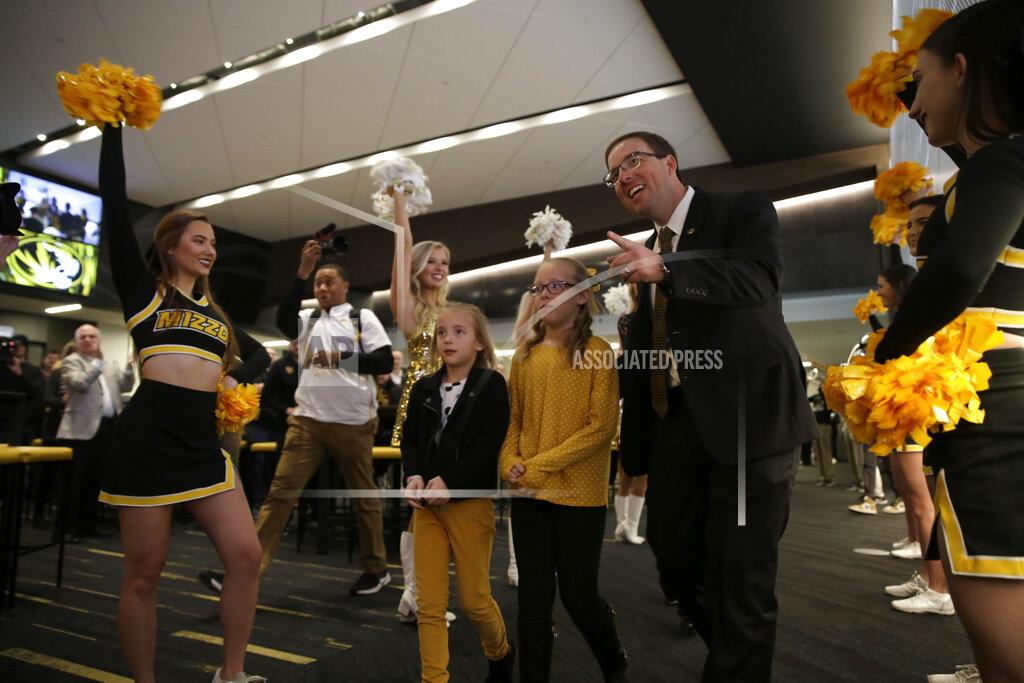 Jeff Roberson ADDS THE CHILDREN'S NAMES - Eliah Drinkwitz walks to the stage to be introduced as the new NCAA college football head coach at the University of Missouri, with his children Emerson, 6, left, and Addison, 9, Tuesday, Dec. 10, 2019, in Columbia, Mo. Drinkwitz becomes the 33rd head football coach at Missouri after coaching the 2019 season at Appalachian State. (AP Photo/Jeff Roberson)