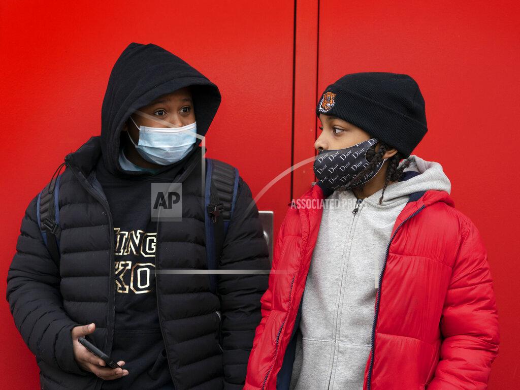 Mark Lennihan Students wait for the doors to open at P.S. 134 Henrietta Szold Elementary School, Monday, Dec. 7, 2020, in New York. Public schools reopened for in-school learning Monday after being closed since mid-November. (AP Photo/Mark Lennihan)