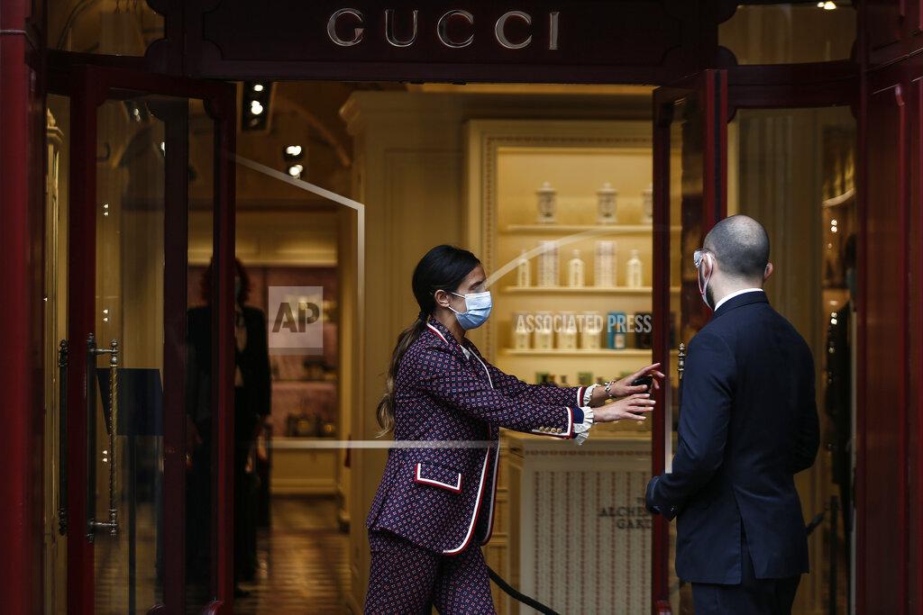 Cecilia Fabiano FILE - In this Monday, May 18, 2020 file photo, employees stand at the Gucci store in Rome. Gucci creative director Alessandro Michele is celebrating the fashion house’s 100-year anniversary, giving historic sweep to a collection unveiled virtually Thursday that embraced its equestrian heritage, borrowed references from the Tom Ford-era and outright stole from a sister brand Balenciaga. (Cecilia Fabiano/LaPresse via AP)