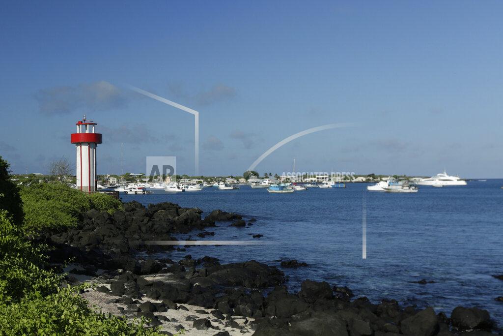 Adrian Vasquez This May 2, 2020 shows the Mann beach lighthouse and boats anchored in Naufragio Bay, amid the new coronavirus pandemic, in San Cristobal, Galapagos Islands, Ecuador. "The base of our economy has entirely collapsed," said Norman Wray, governor of the islands. "This is completely changing the future of tourism in the Galapagos." (AP Photo/Adrian Vasquez)
