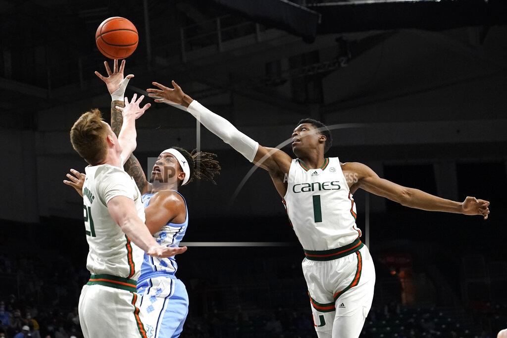 Lynne Sladky North Carolina forward Armando Bacot, center, goes to the basket as Miami forward Sam Waardenburg (21) and forward Anthony Walker (1) defend during the first half of an NCAA college basketball game, Tuesday, Jan. 18, 2022, in Coral Gables, Fla. (AP Photo/Lynne Sladky)
