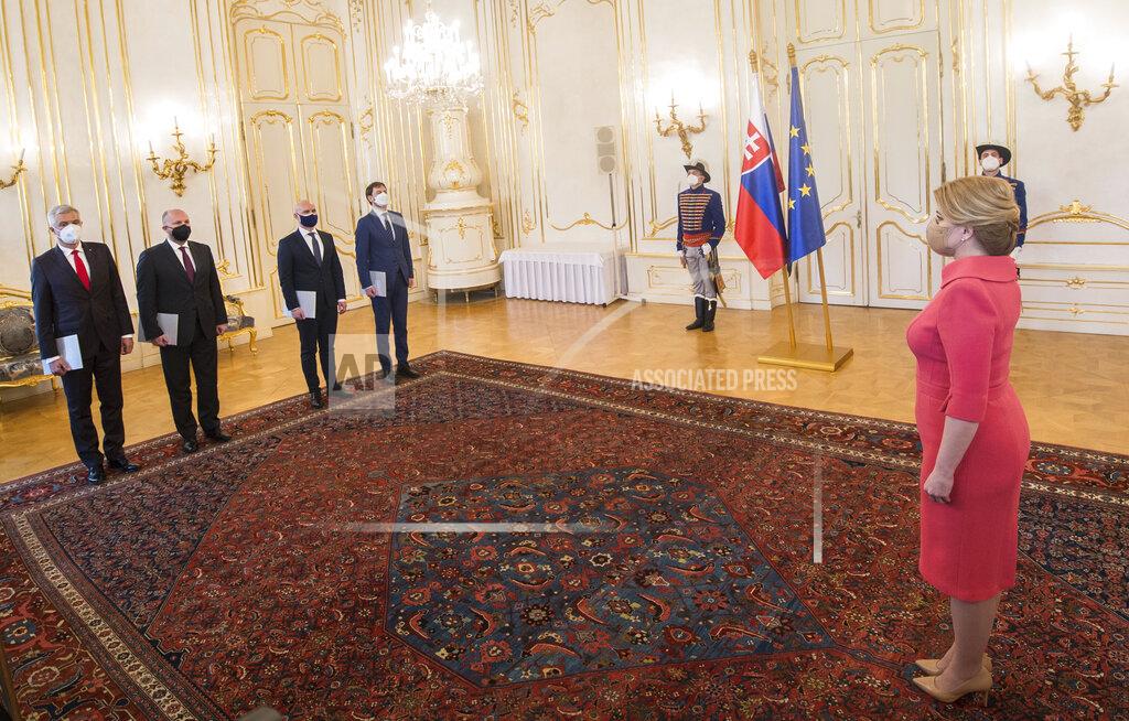 Slovakia's President Zuzana Caputova, right, stands opposite from left, outgoing Foreign Affairs Minister Ivan Korcok, Defence Minister Jaroslav Nad commissioned to head Slovak diplomacy on a temporary basis, outgoing Education Minister Branislav Groehling and Finance Minister Eduard Heger commissioned to head Education Ministry on a temporary basis, as the two ministers resign, at the Presidential Palace in Bratislava, Slovakia, Thursday, March 25, 2021. A party in Slovakia’s ruling coalition has completed its withdrawal from the government amid a political crisis triggered by a secret deal to buy Russia’s coronavirus vaccine. Two ministers of the Freedom and Solidarity party, the foreign minister and education minister, handed in their resignations to President Zuzana Caputova on Thursday. Their party leader resigned from his post of deputy prime minister on Monday. The Freedom and Solidarity and another coalition party, For People, demanded the resignation of Prime Minister Igor Matovic due to the deal he orchestrated. (Martin Baumann/TASR via AP)