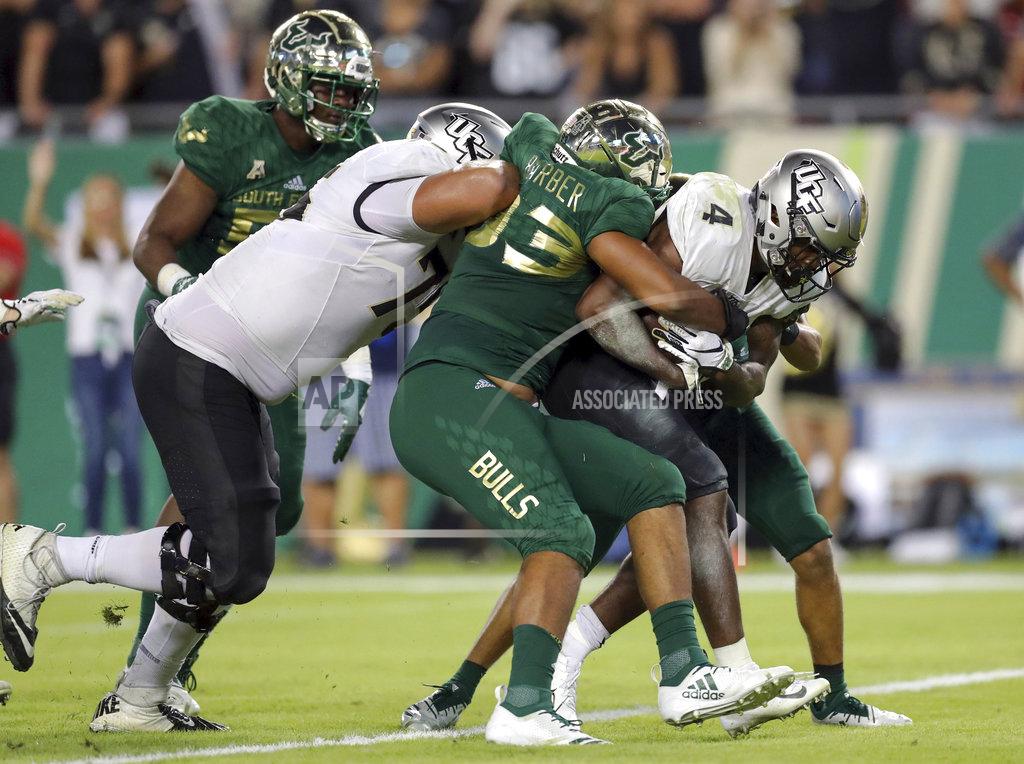 Mike Carlson Central Florida's Taj McGowan fight through an attempted tackle from South Florida's Tyrone Barber to score a touchdown during the second half of an NCAA college football game Friday, Nov. 23, 2018, in Tampa, Fla. (AP Photo/Mike Carlson)