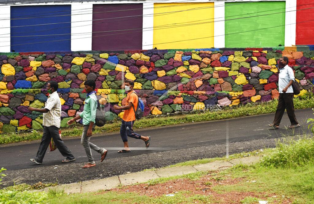 R S Iyer Indian laborers wearing masks arrive for work in the morning in Kochi, Kerala state, India, Friday, May 22, 2020. India's central bank on Friday cut its key interest rate to 4% to revive the economy severely hit the coronavirus outbreak and a two-month lockdown. (AP Photo/R S Iyer)