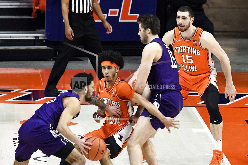 Holly Hart Northwestern's guard Boo Buie (0) pushes Illinois guard Andre Curbelo (5) as teammate center Ryan Young (15) sets a block on forward Giorgi Bezhanishvili (15) in the first half of an NCAA college basketball game Tuesday, Feb. 16, 2021, in Champaign, Ill. (AP Photo/Holly Hart)