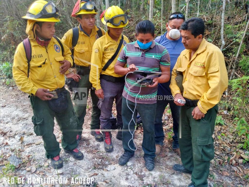 Aderito Chayax In this undated photo provided by the Association of Forest Communities of Petén on June 2020, Alvaro Ba operates a drone within the BioItza reserve in northern Guatemala to assess the characteristics of a forest fire. Alvaro is an associate of one of the community organizations that forms ACOFOP, which works to protect forests within Guatemala's Maya Biosphere. In 2020, the region has experienced a worrisome uptick in fires set illegally to clear land, while government resources to control flames have been diverted to manage the COVID-19 pandemic. (Aderito Chayax/ACOFOP via AP)