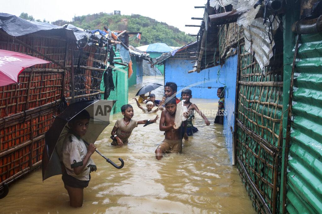 Shafiqur Rahman Rohingya refugee children play in flood waters at the Rohingya refugee camp in Kutupalong, Bangladesh, Wednesday, July 28, 2021. Days of heavy rains have brought thousands of shelters in various Rohingya refugee camps in Southern Bangladesh under water, rendering thousands of refugees homeless. (AP Photo/ Shafiqur Rahman)