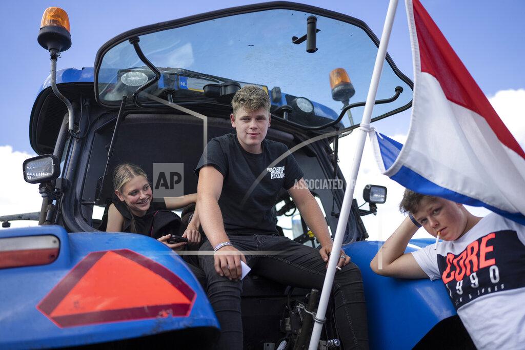 Peter Dejong Protesting farmers and their children sit in their tractors at a blockade outside a distribution center for supermarket chain Aldi in the town of Drachten, northern Netherlands, Monday, July 4, 2022. Dutch farmers angry at government plans to slash emissions used tractors and trucks Monday to blockade supermarket distribution centers, the latest actions in a summer of discontent in the country's lucrative agricultural sector. (AP Photo/Peter Dejong)