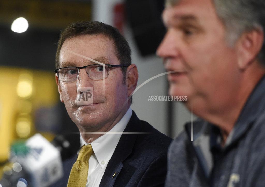Georgia Tech athletic director Todd Stansbury, left, looks at Paul Johnson during a press conference about Johnson's retirement, Thursday, Nov. 29, 2018, in Atlanta. Johnson, the longest-serving Georgia Tech NCAA college football coach in a half-century, announced his retirement Wednesday after 11 seasons with the team. (AP Photo/Annie Rice)