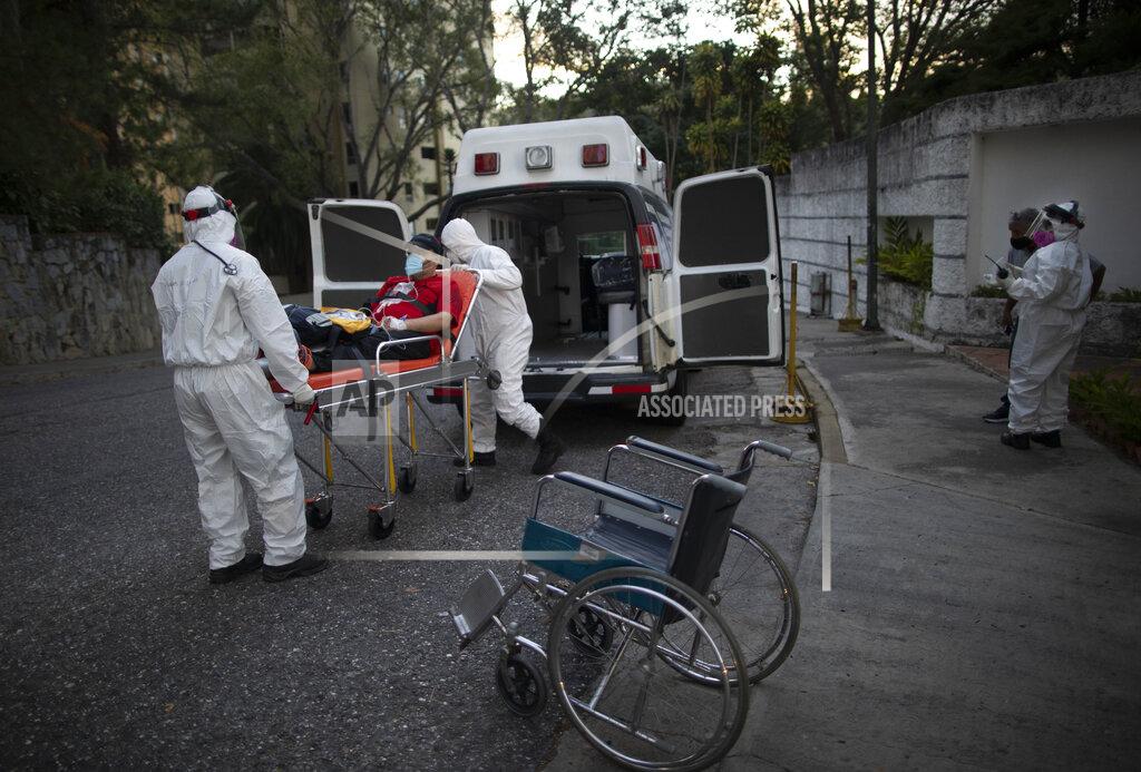 Ariana Cubillos Angels of the Road volunteer paramedics transfer a person suspected of having COVID-19 into their one ambulance, in Caracas, Venezuela, Thursday, Feb. 11, 2021. Each day brings on average three to four calls, and the new coronavirus pandemic means that at least one of those is a request to take a patient with trouble breathing to a hospital. (AP Photo/Ariana Cubillos)