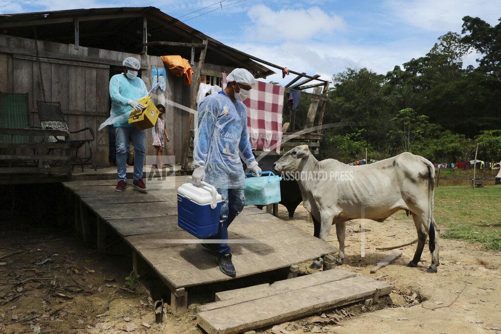 Edmar Barros Health workers Diego Feitosa Ferreira, 28, right, and Clemilton Lopes de Oliveira, 41, leave a home after a resident denied to be vaccinated against the new coronavirus, in the Capacini community, along the Purus river, in the Labrea municipality, Amazonas state, Brazil, Friday, Feb. 12, 2021. Getting the vaccine to the world's farthest corners means delivering it by boat to Maine's islands, traveling by snowmobile to villages in Alaska and navigating complex waterways in Brazil's Amazon. (AP Photo/Edmar Barros)