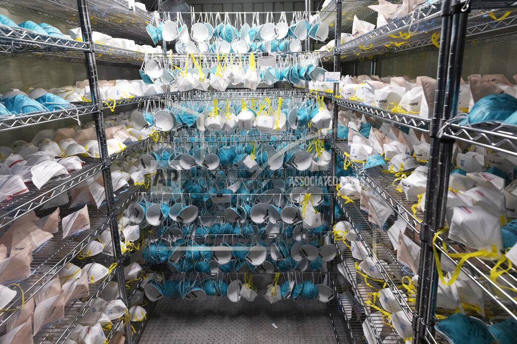 Michael Dwyer FILE - In this Saturday, April 11, 2020 file photo, protective masks hang in a decontamination unit at the Battelle N95 decontamination site during the coronavirus pandemic in Somerville, Mass. Before the coronavirus struck, N95 masks were single use. A nurse could use a dozen a day. As the pandemic took hold and shortages of masks hit critical levels, the Centers for Disease Control and Prevention changed their guidance on the use of the masks in hospitals, allowing for N95s to be reused for days. (AP Photo/Michael Dwyer)