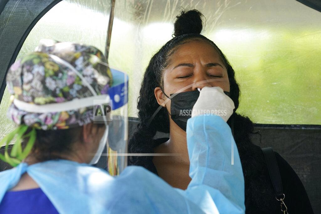 Marta Lavandier Chantel Powell gets a COVID-19 PCR test in order to travel later this week at a Miami-Dade County testing site, Monday, July 26, 2021, in Miami. More than 73,000 new coronavirus cases were reported in Florida over the previous week, according to the state health department, nearly seven times the 12,000 reported a month ago. (AP Photo/Marta Lavandier)