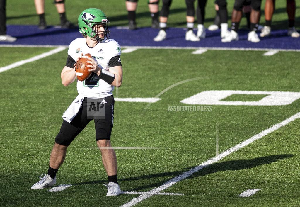 Daniel Lin North Dakota quarterback Tommy Schuster (2) looks for an open receiver during the first half of a quarterfinal game against James Madison in the NCAA FCS football playoffs in Harrisonburg, Va., Sunday, May 2, 2021. (Daniel Lin/Daily News-Record via AP)
