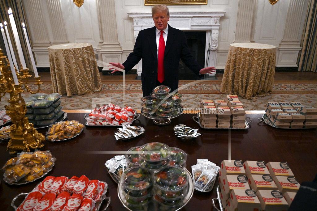 Susan Walsh President Donald Trump talks to the media about the table full of fast food in the State Dining Room of the White House in Washington, Monday, Jan. 14, 2019, for the reception for the Clemson Tigers. (AP Photo/Susan Walsh)