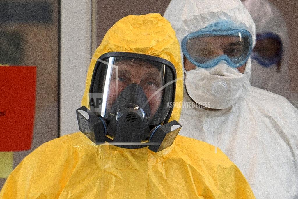 Alexei Druzhinin FILE - In this file photo taken on Tuesday, March 24, 2020, Russian President Vladimir Putin wearing a protective suit enters a hall during his visit to the hospital for coronavirus patients in Kommunarka, outside Moscow, Russia. Russian authorities declared a war on "fake news" related to the new coronavirus. The crusade was triggered by what looked like a real disinformation campaign, but as the outbreak in Russia picked up speed and criticism of the Kremlin's "it is under control" stance mounted, the authorities cracked down on social media users doubting the official numbers and news outlets questioning the government's response to the epidemic. (Alexei Druzhinin, Sputnik, Kremlin Pool Photo via AP, File)